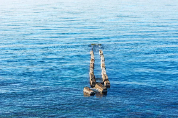 stock image Concrete breakwater in the tranquil sea.