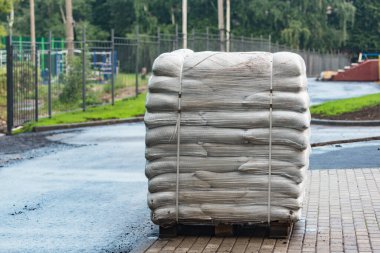 İnşaat alanının yanındaki palette toprak olan büyük çantalar..