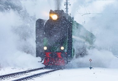 Retro buhar treni kış karlı bir zamanda tren istasyonuna yaklaşıyor..