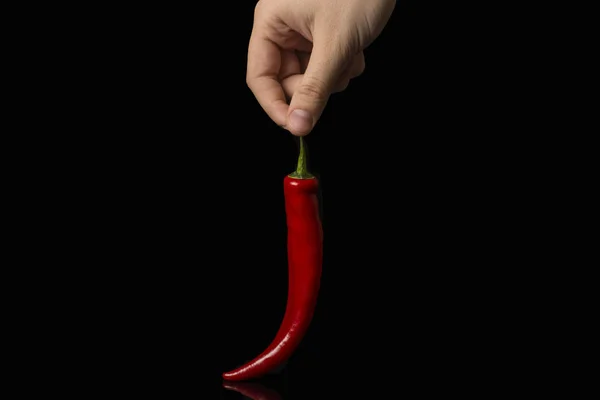 Κόκκινο ζεστό πιπέρι άνθρωπος χέρι του ανθρώπου μαύρο φόντο — Φωτογραφία Αρχείου