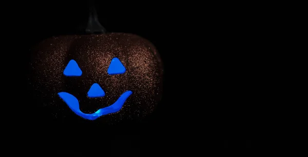 Goede Halloween pompoen op een zwarte achtergrond. Vrije ruimte voor tekst. Blauwe ogen.Vooraanzicht — Stockfoto