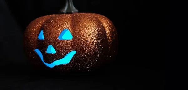 Goede Halloween pompoen op een zwarte achtergrond. Zijaanzicht.. Vrije ruimte voor tekst.. Blauwe ogen. — Stockfoto