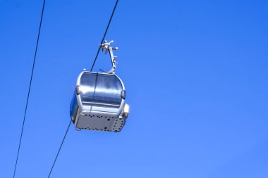 Kablo araba kaldırma kabini mavi gökyüzüne karşı açık. Kayak merkezinde füniküler veya teleferikler.