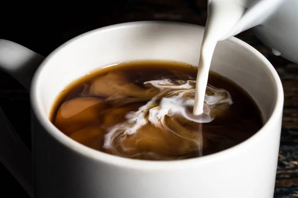 Öntés krém egy csésze kávé Stock Kép