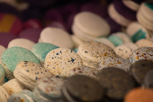 カラフルなケーキマカロン、フランスのマカロンがカウンターの上に。複数色のマカロンが列に並んでいます。. — ストック写真