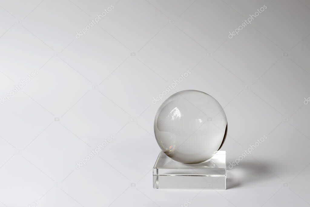 Crystal ball, glass ball on a stand. Interior detail, home design item. Simple shapes. Minimalism and balance concept, copy space for your design.