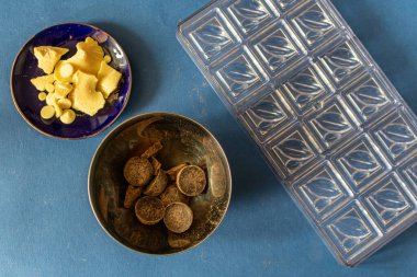 Kalıpların yanında koyu acı çikolata ve beyaz çikolata parçaları var. Şekersiz sağlıklı şekerler pişirme süreci.