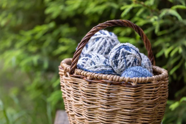 スプルースの緑の枝を背景に籠の中の白い青いふわふわの毛糸玉 コピースペース付き水平ポスター 編み物用糸 — ストック写真