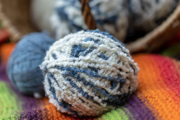 自然を背景に籠の中の毛糸の白い青いふわふわのボールが閉じ込められています 編み物の糸 女性の針仕事のための項目 — ストック写真