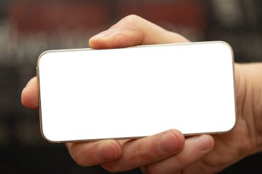 Metin mesajınız veya bilgi içeriğiniz için boş kopya alanı olan akıllı telefonu tutan adamın kırpılmış görüntüsü