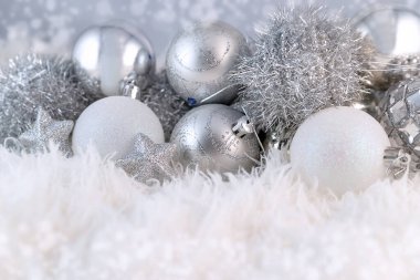 Gümüş Noel topları olan bir poster. Kabarık beyaz kürk arka planında fotokopi alanı olan güzel bir Noel kompozisyonu.