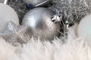 Gümüş Noel topları olan bir poster. Kabarık beyaz kürk arka planında fotokopi alanı olan güzel bir Noel kompozisyonu.