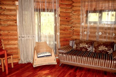 Ahşap bir evde taşra tarzında basit bir iç mekan. Kütük duvarlı salon