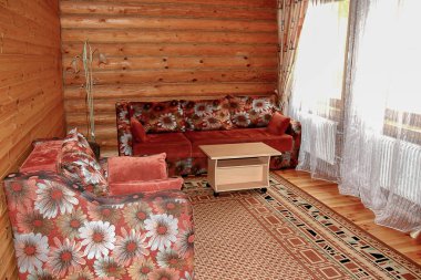 Ahşap bir evde taşra tarzında basit bir iç mekan. Kütük duvarlı salon