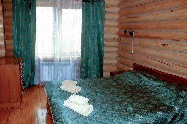 Ahşap bir evde taşra tarzında basit bir iç mekan. Kütük duvarlı modern kırsal yatak odası