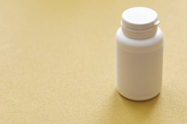 Sarı arka planda beyaz tıbbi konteynır. Geleneksel tıbbi araç, sağlık kavramı.