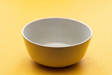 Sarı zemin üzerinde boş beyaz bardak, izole.