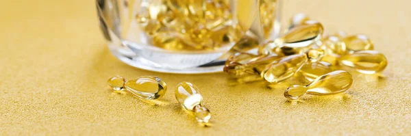 Omega 3 'lü balık yağı kapsülleri ve sarı arka planda D vitamini. Sağlıklı vitaminler. Metnin için bir kopya alanı. Minimalist soyut tıp kavramı.