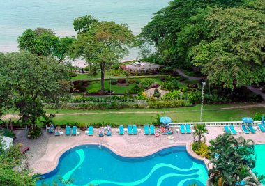 Mavi su, güneş pansiyonları, Pattaya, Tayland 'daki otel havuzunun üst manzarası.