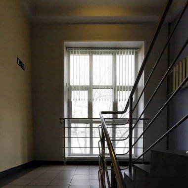 Bir şehir binasının içi kavramı. Katlar arasında metal korkuluklu bir merdiven fotoğrafı..
