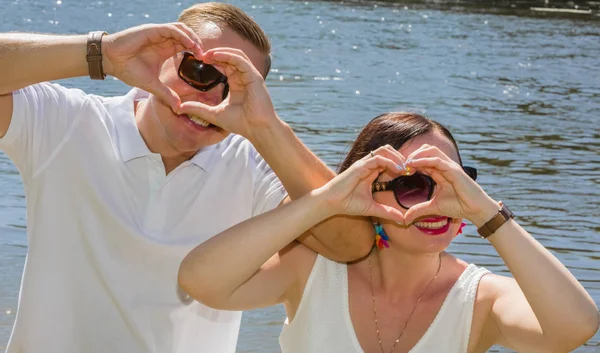The happy young couple shows hands the sign of love