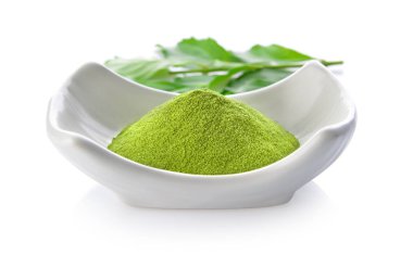 Beyaz arka planda bir kasede yeşil çay tozu