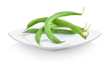 Beyaz arka plan üzerinde beyaz seramik tabak yeşil fasulye