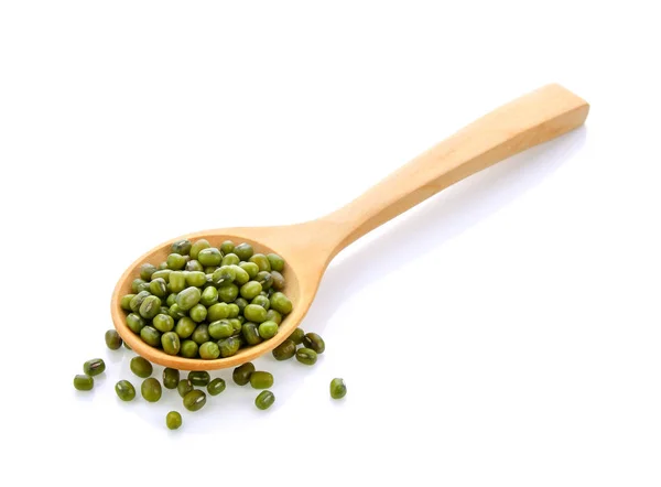 白い背景の上の木製のスプーンで緑色の豆種子 — ストック写真