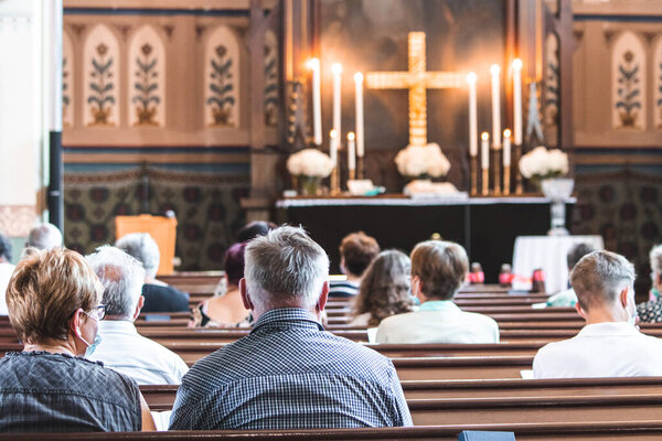 Holy mass in Christian church during the coronavirus pandemic Covid-19. Safe personal distance with face masks. Chruch during pandemics