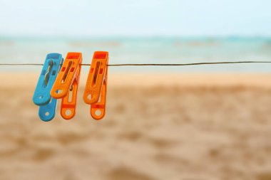 Konsept renkli clothespin bir mavi iki portakal doğa deniz ve plaj arka plan üzerinde sapan ile pin
