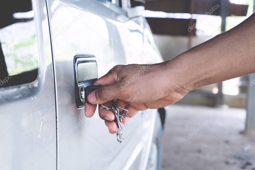 Normal Car key in men hand opening his car