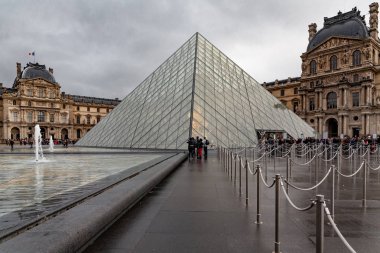 Paris, Louvre sokaklarında yürürken yağmur altında