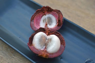 siyah bir tabak içinde mangostin