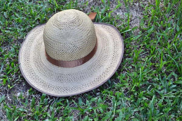Chapéu de palha fêmea na grama — Fotografia de Stock
