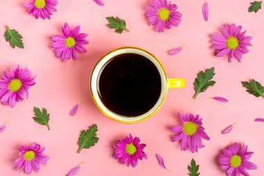 Pembe arka planda çiçekli bir fincan kahve.