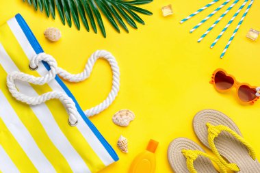 Yüzme aksesuarları - çizgili, güneş kremi, kalp şeklinde gözlük, fiske, palmiye, deniz kabuğu, tablet sarı arka planda Üst Manzara Seyahat, tatil, çevrimiçi rezervasyon konsepti.