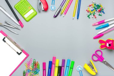 Okul ve ofis malzemelerinden çerçeve ataç, makas, kalem, keçeli kalem, kalemler, bileyici, hesap makinesi, zımba gri arka planda izole edilmiş düz zemin, okula geri dön, eğitim konseptini düzenle.