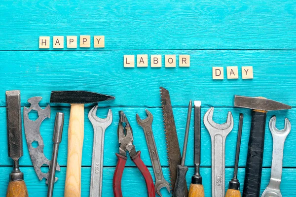 Happy Labor day concept Construction group home tools - hammer, saw, screwdriver, meter, pliers, wrench, chisel on blue wooden background Holiday card Top view Flat lay Text Banner.