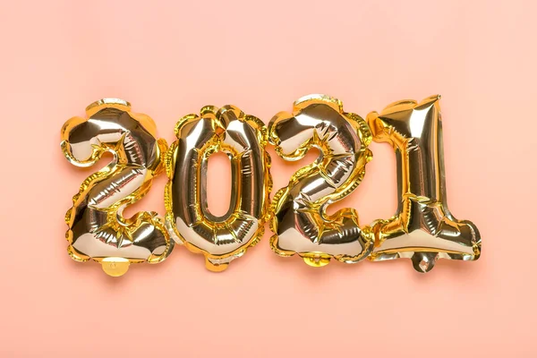 Gold foil balloons numeral 2021 isolated on beige background Flat lay creative composition Top view Happy New year 2021, Merry Christmas concept Holiday card — Stock Photo, Image