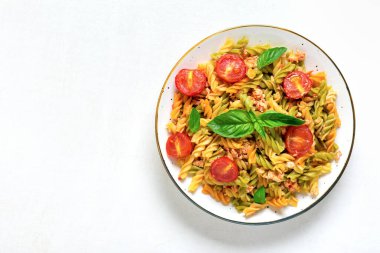 Fusilli - Tavuklu buğday, domates vişneli, fesleğenli domates soslu klasik İtalyan makarnası ahşap masada beyaz kase içinde Akdeniz mutfağı