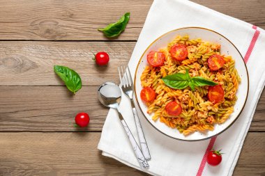 Fusilli - Tavuklu buğday, domates vişneli klasik İtalyan makarnası, domates soslu fesleğen, beyaz kâse, kaşık, ahşap masa çatalı Akdeniz mutfağı