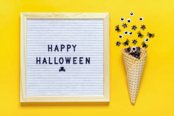 Felt board with text, quote, black spiders and flies, googly eyes crawl out of ice cream cone on yellow background Top view Flat lay Happy Halloween creative concept Holiday card — Stock Photo, Image