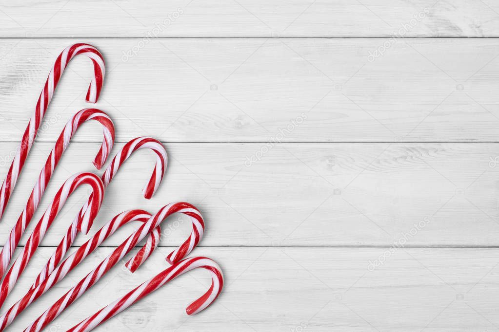 Christmas candy canes on white wooden background