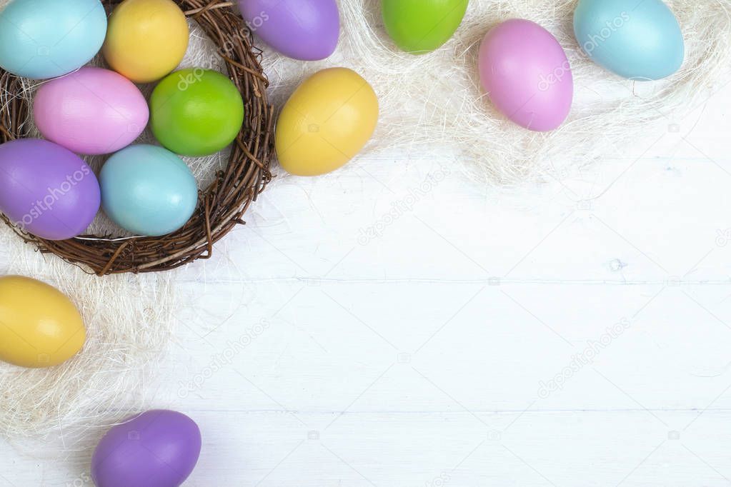 Multi-colored easter eggs in a nest on a white background