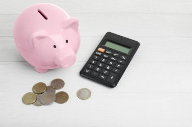 Pembe seramik kumbara ve beyaz arka plan üzerinde paralar