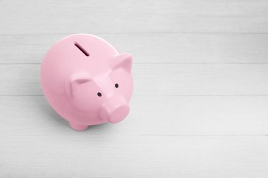 Beyaz ahşap zemin üzerinde seramik pembe kumbara