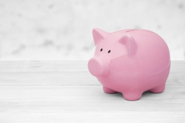 Beyaz ahşap zemin üzerinde seramik pembe kumbara