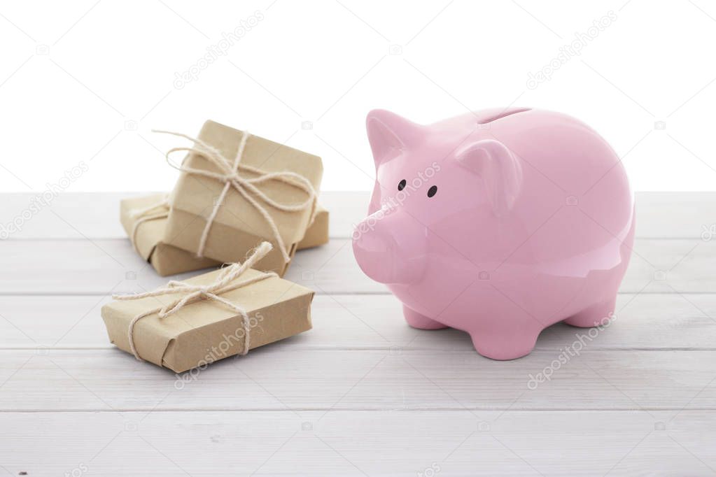 Ceramic pink piggy bank and gift boxes on white background