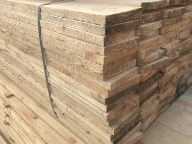 Arka plan ve doku için inşaat malzemesi. Ahşap ürünler, kalaslar, astarlar, inşaat tahtaları malzeme deposunda. Kereste endüstrisi nesneleri.