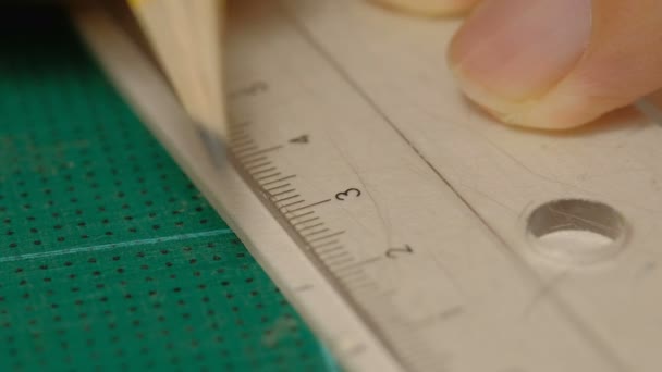 定規と鉛筆で白い板紙にマークを描く男性建築家のクローズアップ モデル作成プロセス — ストック動画